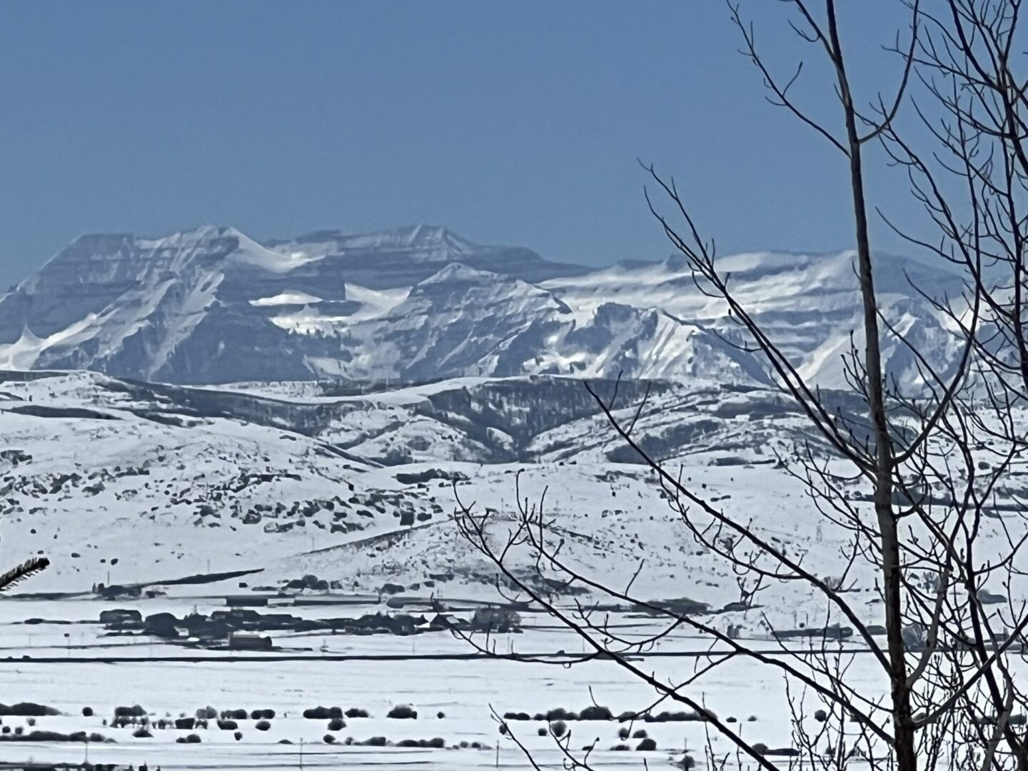 A snow covered field with mountains in the background.