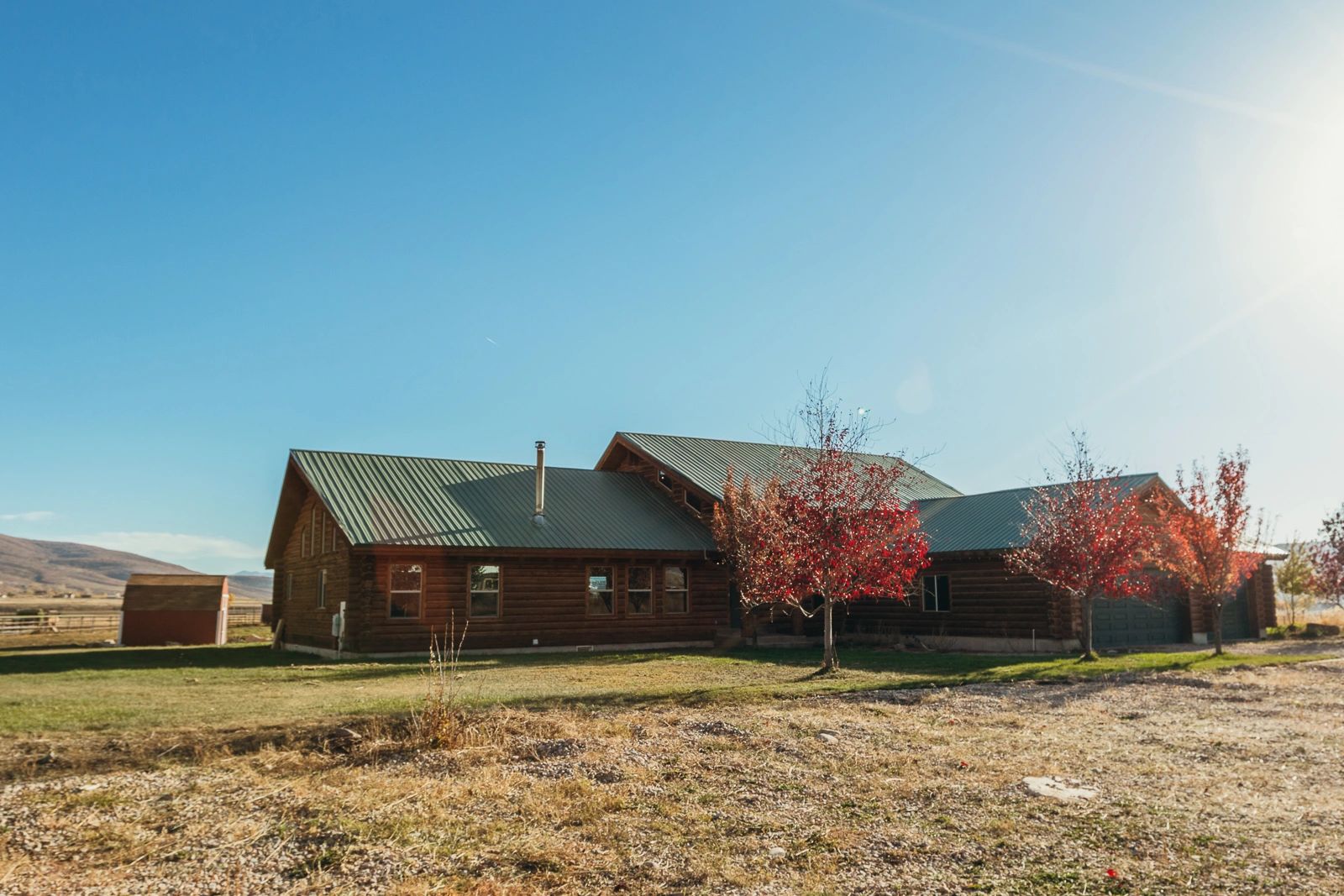 A large log cabin in the middle of a field.