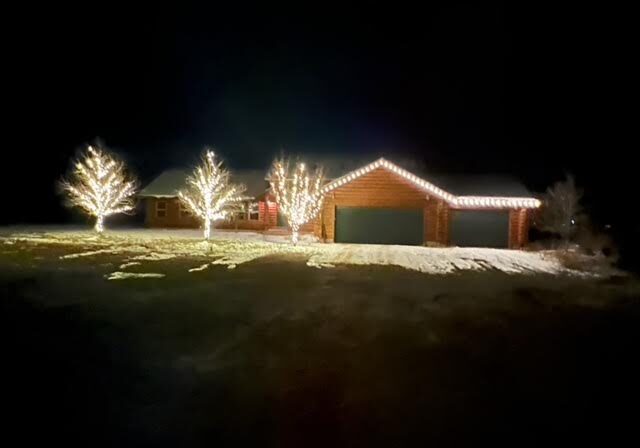 A house is lit up at night with christmas lights.